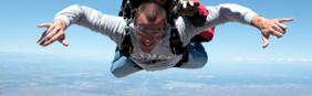 Ed throwing shaka while tandem skydiving