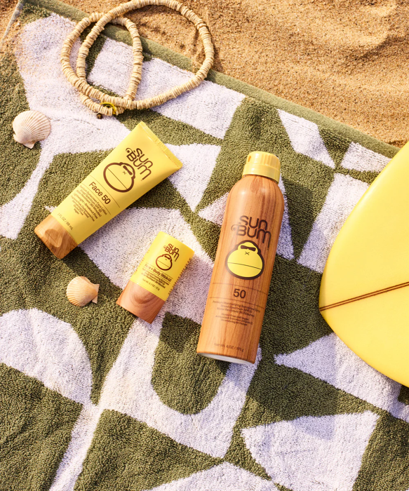 Sun Bum products on a beach towel